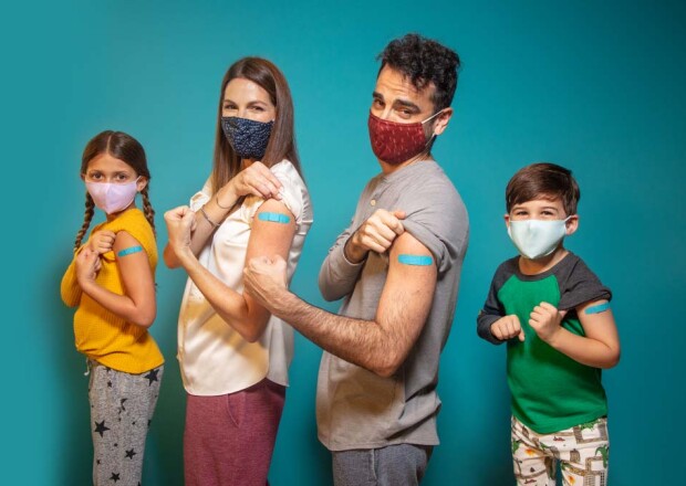 Familia con máscaras con tiritas en los brazos