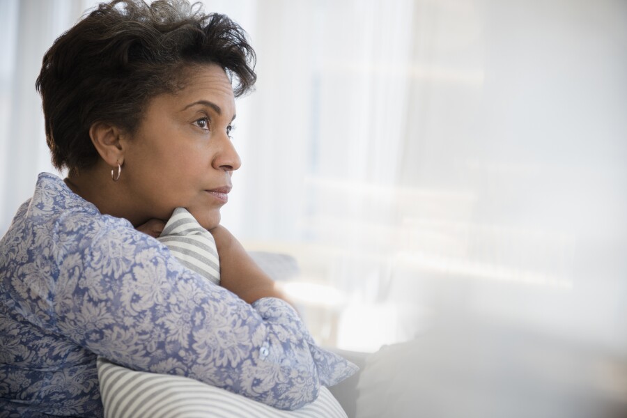 Pensive woman clutching pillow