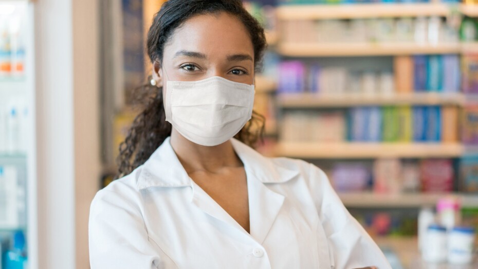 mujer que trabaja en una farmacia con una mascarilla