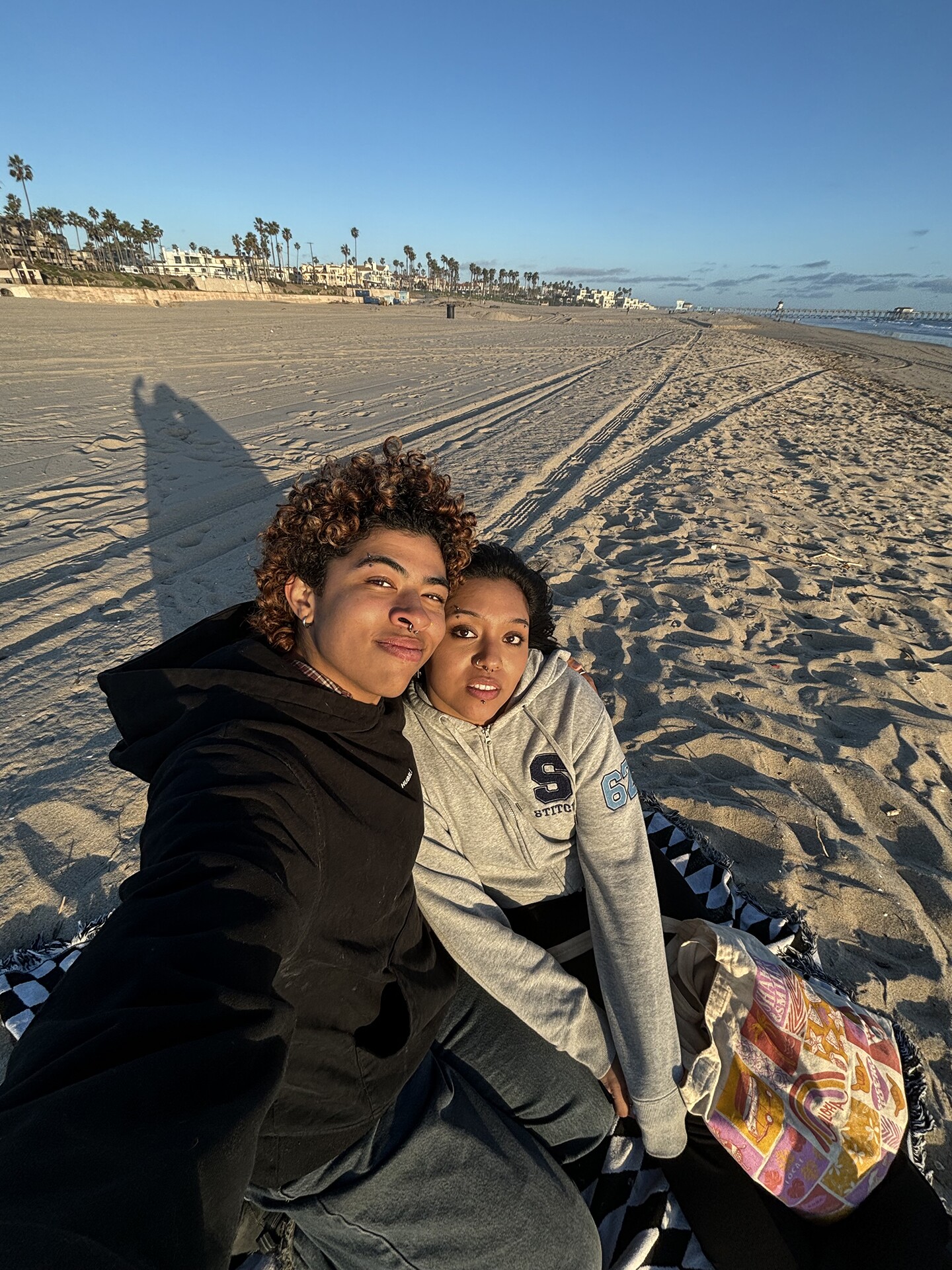 Dawn and his partner sitting on the beach.